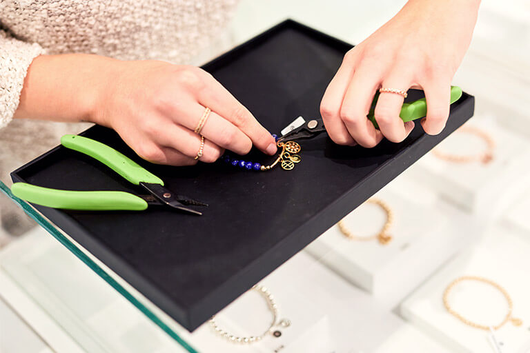 Francesca staff making a bracelet by hand.